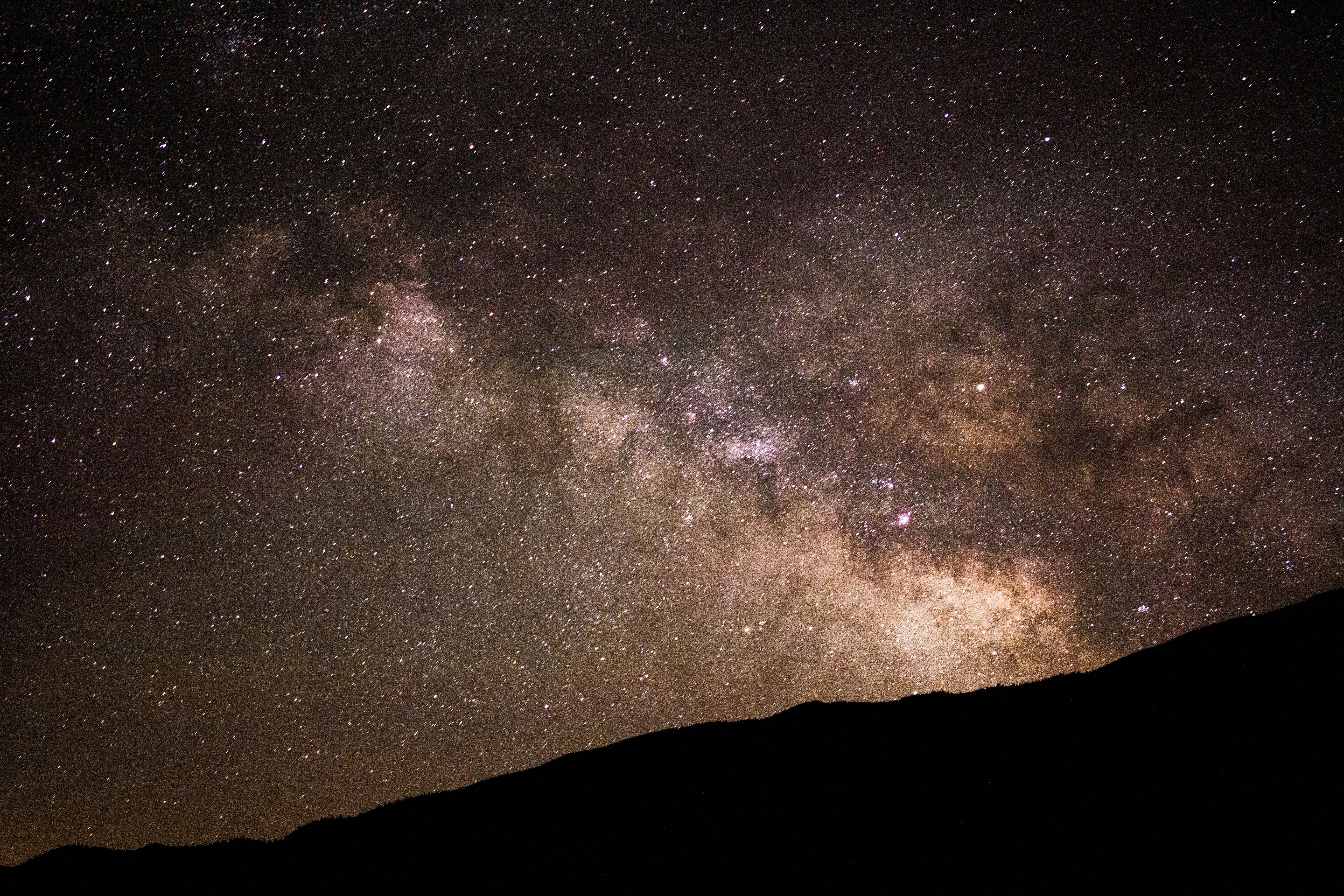 silhouette of hill under starry sky